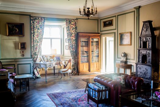 Intérieur élégant d'une chambre d'hôtes avec bibliothèque, fauteuils vintage et décorations raffinées au Château de Sainte-Ju