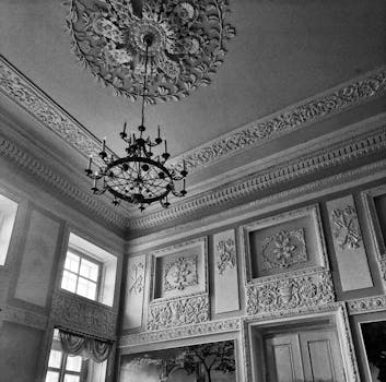 Plafond orné avec lustre et moulures détaillées dans une chambre du Château de Sainte-Julie.